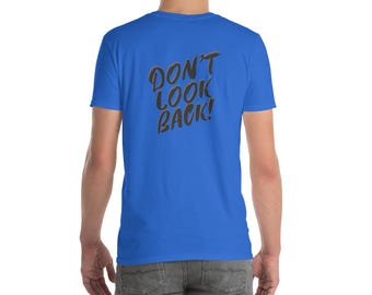 May include: A royal blue t-shirt with the text "DON'T LOOK BACK!" in a stylized, dark gray font. The shirt is short-sleeved and appears to be made of a soft material. The back of the shirt is visible.