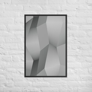 May include: Framed abstract art print featuring a geometric design in shades of gray and white. The artwork has a three-dimensional effect created by lines and shapes. The print is encased in a black frame and mounted on a white brick wall.