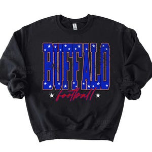 May include: Black crew neck sweatshirt with the word "BUFFALO" in blue block letters with white stars, and the word "football" in red script. A classic design for fans of the Buffalo football team.