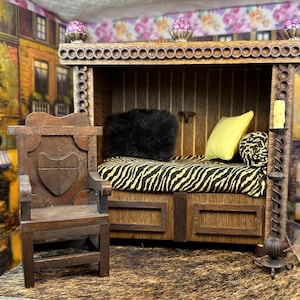 Può includere: Un letto in legno in miniatura con un materasso a stampa zebrata, un cuscino nero e un cuscino giallo. Una sedia in legno con uno scudo intagliato sullo schienale si trova davanti al letto. Un portacandele decorativo in metallo con una candela si trova accanto al letto.