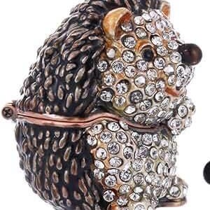 May include: A small, decorative, jeweled hedgehog trinket box with a hinged lid. The hedgehog is made of metal and has a brown and black finish. The hedgehog is covered in clear rhinestones.