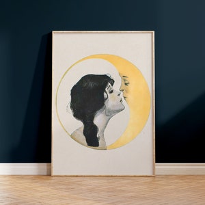 May include: Framed vintage art print featuring a woman and a crescent moon in a romantic embrace. The artwork is in a soft color palette with a cream background, a yellow moon, and a woman with dark hair. The frame is a light wood color.