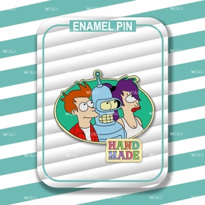 May include: An enamel pin featuring characters from the animated series Futurama. The pin includes Fry, Bender, and Leela, set against a green background. The pin is labeled "ENAMEL PIN" and "HAND MADE".