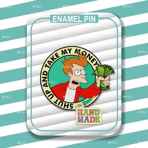 May include: Enamel pin featuring a cartoon character holding money with the phrase "SHUT UP AND TAKE MY MONEY." The pin has a handmade design and is set against a white and teal striped background.