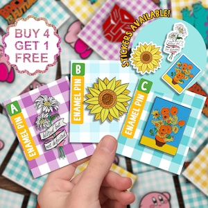 May include: Three enamel pins with different designs. The first pin features a bouquet of white daisies with a banner that reads "Wilted but not defeated". The second pin is a yellow sunflower. The third pin is a painting of sunflowers. The pins are on a light blue background with a white checkered pattern. The text "ENAMEL PIN" is on each card. The text "STICKERS AVAILABLE!" is on a blue background with a white checkered pattern.