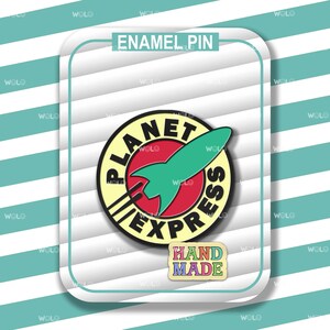 May include: Enamel pin featuring the Planet Express logo with a green rocket and the text "Planet Express". The pin has a red background and a yellow border. A smaller "Hand Made" pin is also included.