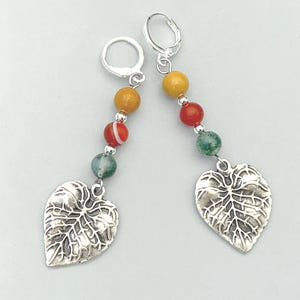 May include: A pair of drop earrings featuring silver-toned leverback hooks, each suspending a vertical arrangement of three round beads in yellow, red, and green, finished with a textured silver-toned metal leaf charm at the bottom.