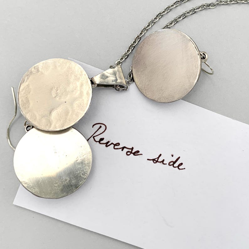 Back view of domed silver earrings with pewter base and sterling hooks.