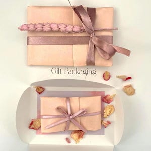 Gift packaging upgrade shown featuring blush tissue, ribbon, wheat stem and rose petals
