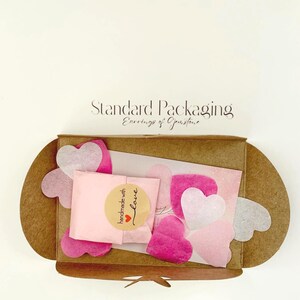 Standard packaging with natural card envelope, shops card and shades of pink confetti
