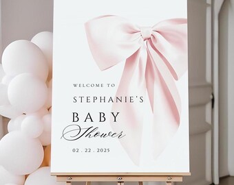 May include: A white welcome sign with a large pink bow on top. The sign reads "Welcome to Stephanie's Baby Shower 02.22.2025".