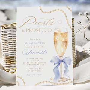 May include: A bridal shower invitation with a watercolor illustration of a champagne flute with a blue ribbon and pearls. The text reads "Pearls & Prosecco" and includes the bride's name, date, time, and location.