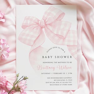 May include: A pink and white gingham bow on a white background. The text reads "Please join us for a baby shower honouring the mother-to-be Brittany Wilson. Saturday, February 22, 2 PM. 1201 Rickenbacker Causeway, Key Biscayne, FL 33149. RSVP by Jan. 8th at 123-456-7537. Registered at Store Name."