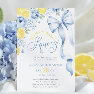 Puede incluir: Invitación a un baby shower con un lazo azul y diseño floral. La invitación presenta el texto "Mama's Main Squeeze" y detalles del evento, incluyendo fecha, hora y lugar. Limones y flores azules decoran la parte superior.