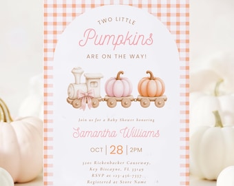 May include: A rectangular baby shower invitation card with a light orange gingham border. The center features an arched design with a watercolor train carrying two pumpkins, one pink and one orange. Text reads: Two Little Pumpkins Are On The Way!