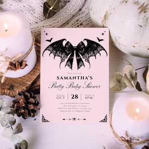 May include: A pink baby shower invitation with a black bat wing bow design. The invitation includes the text "SAMANTHA'S Batty Baby Shower" and event details. The invitation is surrounded by candles, a pumpkin, and decorative elements.