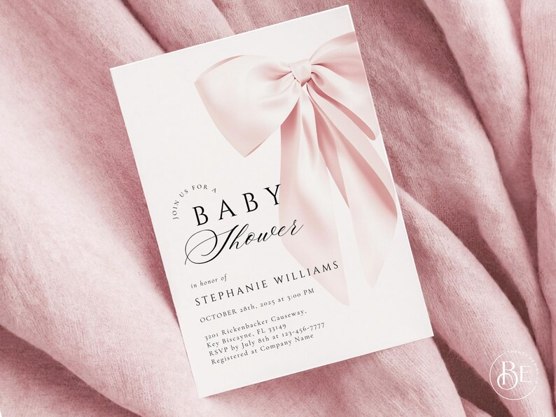 May include: A white baby shower invitation with a pink satin bow. The invitation reads "Join us for a Baby Shower in honor of Stephanie Williams, October 28th, 2015 at 3:00 PM, 1100 Rickenbacker Causeway, Key Biscayne, FL 33149, RSVP by July 8th at 123-456-7777, Registered at Company Name."