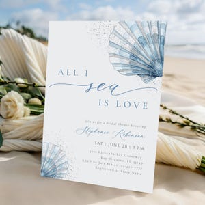 May include: A white invitation card with blue watercolor seashell illustrations and the text "ALL I sea IS LOVE". The card is for a bridal shower, with details including the date, time, and location.