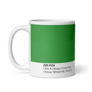 Può includere: Tazza in ceramica bianca con un campione di colore verde e il testo "ZZ9 PZA I Am A Hoopy Frood And I Know Where My Towel Is"