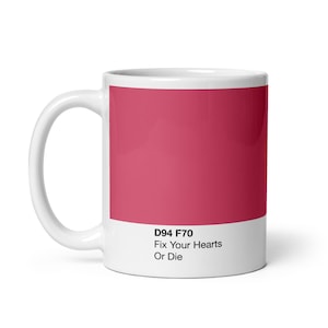 Könnte beinhalten: Weiße Keramiktasse mit einem roten Farbmuster und dem Text "D94 F70 Fix Your Hearts Or Die" auf dem Boden.