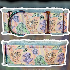 May include: A pet collar featuring a pastel orange and pink wavy background with a repeating pattern of cartoon dinosaurs and butterflies. The collar is lined with light blue faux fur and includes iridescent metal hardware, including a D-ring.