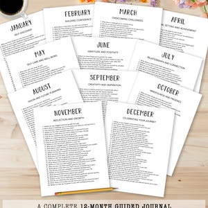 May include: A complete 12-month guided journal with prompts for self-reflection. The journal pages are white with black text, organized by month, and include prompts for self-discovery, gratitude, and goal setting. A pencil rests on the bottom.