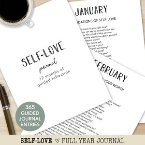 May include: A white Self-Love journal with the text "Self-Love journal, 12 months of guided reflection." The journal includes 365 guided journal entries. A cup of coffee and a pen are also in the image.