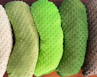 May include: Five crescent-shaped pillows arranged in a row, featuring a textured dimpled surface. The colors range from left to right: cream, light olive green, bright lime green, forest green, and a dark brown, all with a consistent dot pattern.