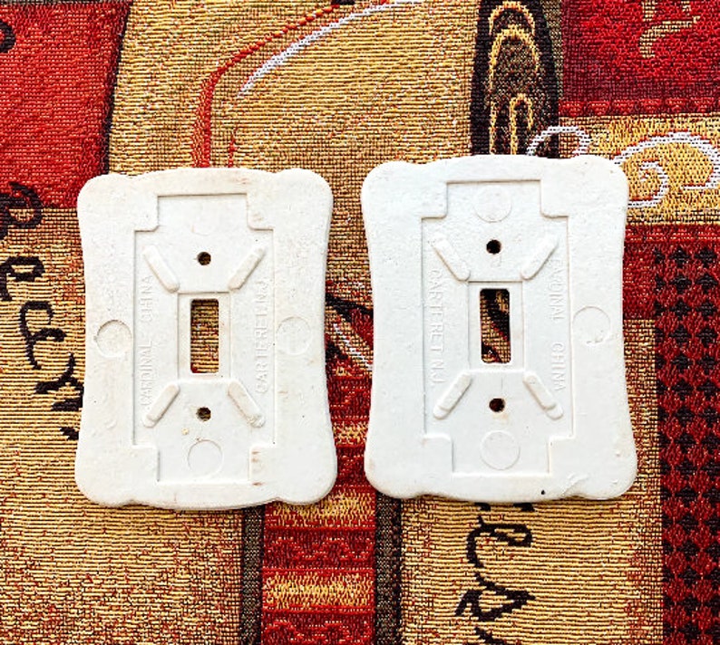 May include: Two white ceramic light switch plates with the text "Cardinal China" and "Carteret N.J." printed on them.