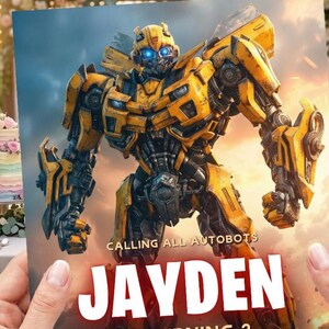 May include: A rectangular print featuring the yellow and black robot character Bumblebee with glowing blue eyes. The text CALLING ALL AUTOBOTS is printed above the large white name JAYDEN, set against a background of a cloudy, orange-toned sky.