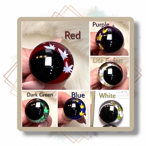 May include: A collection of six round, spherical objects featuring a dark circular center and a colored outer ring with white or gold leaf-shaped accents. The colors include red, purple, light green, dark green, blue, and white, each labeled accordingly.