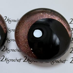 May include: A pair of black and brown glass eyes with a glitter finish. The eyes have a white pupil and a black iris.