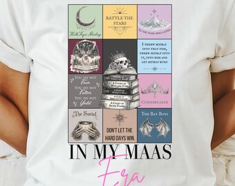 May include: White t-shirt featuring a colorful graphic design with text. The design includes various images and text blocks, with the words "IN MY MAAS era" in pink script. The shirt is made of a soft material.
