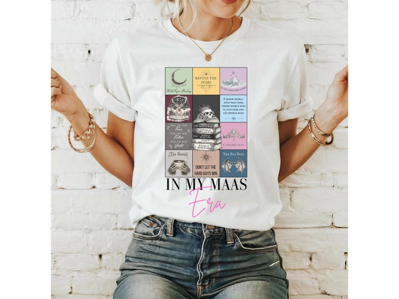 K&ouml;nnte beinhalten: Wei&szlig;es T-Shirt mit einem farbenfrohen Grafikdesign. Das Design enth&auml;lt verschiedene Bilder und Textbl&ouml;cke, mit den Worten "IN MY MAAS era" in rosa Schrift. Das Shirt besteht aus einem weichen Material.