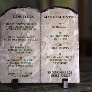 May include: Two stone tablets with the Ten Commandments written in Spanish. The tablets are beige with brown and orange veins. The text on the tablets reads "Los Diez Mandamientos" and lists the ten commandments in Spanish.