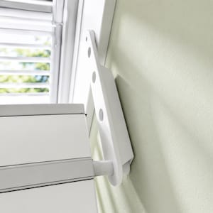 Könnte beinhalten: Eine weiße, klappbare Leiter, die an einem weißen Schrank an einer hellgrünen Wand befestigt ist. Die Leiter hat kreisförmige Aussparungen und lässt sich vom Schrank ausklappen. Der Schrank hat eine graue Zierleiste.