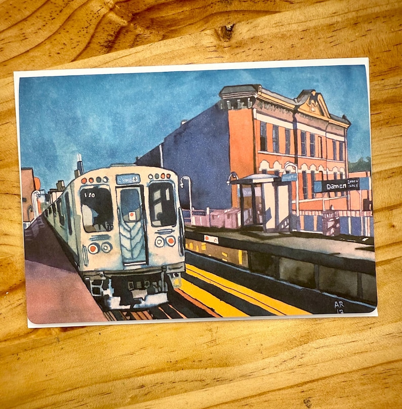 Puede incluir: Pintura a la acuarela de un tren en una estaci&oacute;n. El tren es blanco y gris, con el n&uacute;mero 170 visible. La estaci&oacute;n tiene un letrero que dice "Damen". El cielo es azul y los edificios son naranjas y marrones.