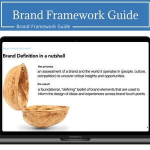 May include: A laptop screen displaying a presentation slide with the title "Brand Definition in a nutshell". The slide features a walnut shell with the text "the process" and "the result" describing the process and result of brand definition.