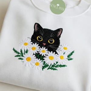 刺繍入り黒猫とデイジーのスウェットシャツ、かわいい黒猫のセーター、猫好きの方へのギフト、ワイルドフラワーシャツ、ボヘミアンコテージコア自然愛好家へのギフト