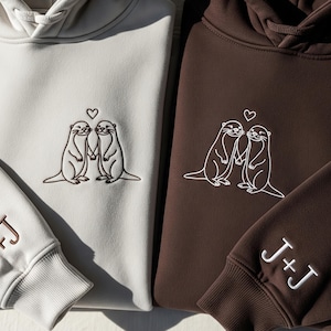 Embroidered Otter Love Matching Couple Hoodie With Personalized Sleeve Initials - Cute Anniversary Sweatshirt Gift For Him And Her