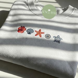Sudadera de cuello redondo con bordado de conchas marinas, sudadera playera minimalista, sudadera náutica de verano, camiseta para amantes del océano costero, regalo de vacaciones estilo surf.