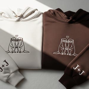 Embroidered Otter Love Matching Couple Hoodie With Personalized Sleeve Initials - Cute Anniversary Sweatshirt Gift For Him And Her