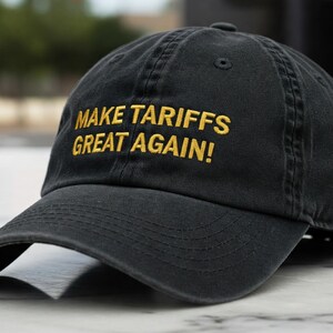 Pode incluir: Um boné de beisebol preto com o texto "MAKE TARIFFS GREAT AGAIN!" bordado em amarelo.