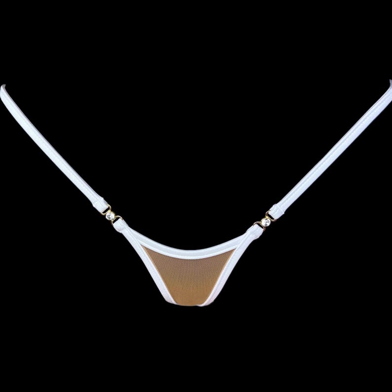 Puede incluir: Braguita de bikini blanca y beige con finas tiras blancas. La braguita del bikini tiene forma triangular con un centro de malla beige y ribete blanco. Las tiras est&aacute;n unidas con herrajes dorados.