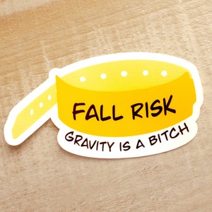 May include: Yellow sticker with the text "Fall Risk" and "Gravity is a Bitch" in black lettering.