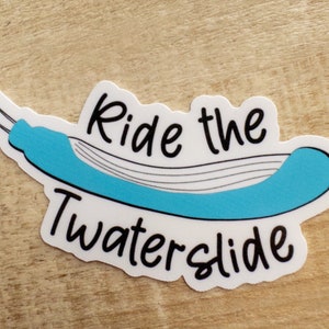 May include: White sticker with the text "Ride the Waterslide" in black cursive font. A blue waterslide is depicted in the center of the sticker.
