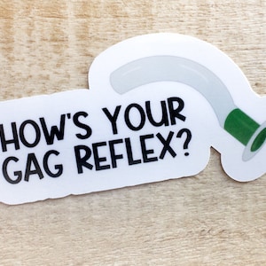 May include: White sticker with black text that reads "How's your gag reflex?" and a cartoon image of a white and green medical suction tube.