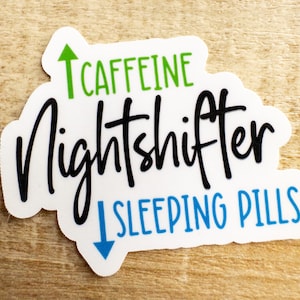 May include: White sticker with black text that reads "Nightshifter" with an upward green arrow and the word "CAFFEINE" above it and a downward blue arrow and the words "SLEEPING PILLS" below it.