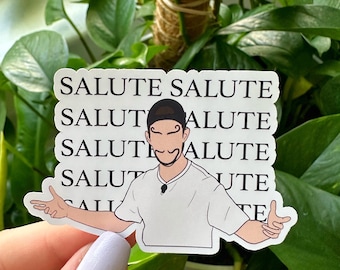 Può includere: Un adesivo bianco con la parola "SALUTE" ripetuta. Presenta un'illustrazione a cartoni animati di una persona con i baffi e le braccia tese. Il testo "Version 1" è in basso.