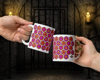 May include: Two white ceramic mugs with a repeating pattern of orange, pink, and purple twenty-sided dice. The mugs are held up in a celebratory gesture against a backdrop of a stone wall and a metal gate.